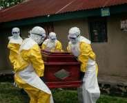 Members of a Congolese Red Cross team carry the coffin of a woman suspected of having died from Ebola in the eastern city of Bunia.  By Jospin Mwisha (AFP)