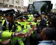 Metropolitan Police officers clash with protesters taking part in a gathering around a bus reportedly waiting to remove migrants and asylum seekers from a hotel in Peckham, south London.  By HENRY NICHOLLS (AFP)