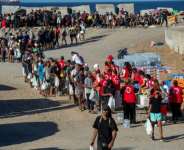 Red Cross volunteers distribute food to migrants who remain living on the streets of Ceuta.  By Antonio Sempere (AFP/File)