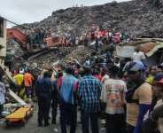 Residents and rescuers use an excavator to search for bodies after a landslide struck a dumpsite in Conakry, Guinea.  By - (AFP)