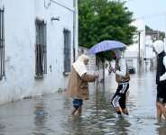 Residents wade across a flooded street in La Goulette, near the capital Tunis, after heavy rainfall swept Tunisia.  By FETHI BELAID (AFP)