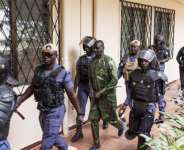 Security officers escort Sanna Manjang (C), a former member of The Gambias Junglers death squad, as he arrives at court. By Muhamadou BITTAYE (AFP)