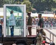 Speculation mounts over who will succeed Ugandan President Yoweri Museveni (L on vehicle).  By BADRU KATUMBA (AFP/File)