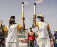 Torchbearers carry the Youth Olympic Flame during its tour through Dakar in September 2026.  By Carmen Abd Ali (AFP/File)