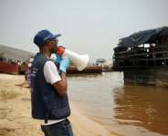 Yves Matwa, an Ebola outbreak response worker, tells passengers on Congo river ferries to brace for checks before they can enter the DR Congo capital Kinshasa.  By Sophie Douce (AFP)