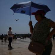 People brave the temperatures at the Trocadero plaza near the Eiffel Tower in Paris during a heat wave July 2, 2025. -  Christophe Ena, AP