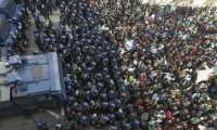 Algerian riot police block the progress of an anti-government demonstration heading towards the presidential palace in the capital Algiers on the first anniversary of the 