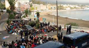 Police escort migrants from Benitez Beach to be relocated to the camp set up at the port of Ceuta, Spain, 18 September 2026. -  REUTERS