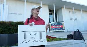 Laura Bligh holds a sign outside the John F. Kennedy Center for the Performing Arts in Washington on September 15, 2026. -  Jacquelyn Martin, AP