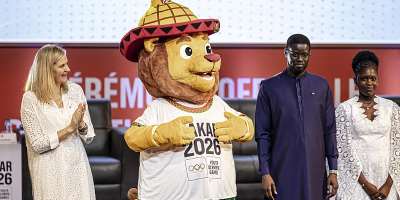 Aya, the official mascot of the 2026 Dakar Youth Olympic Games, flanked by the President of the International Olympic Committee (on the left) and the President of the Republic of Senegal, Bassirou Diomaye Faye. Standing beside her is Ndye Mariama Diop, who won the design competition. - AFP - PATRICK MEINHARDT
