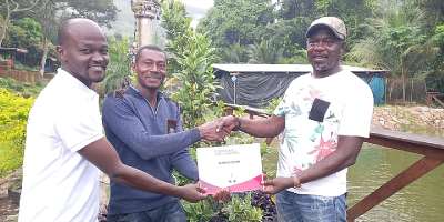 Nana Osei Omari Obrempong II right presenting certificate to a trainee after completion of training