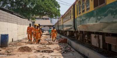Maintenance staff walk along the railway line that connects the Ghanaian capital Accra and the city of Tema. The 25-kilometer route reopened in late January 2020 after rehabilitation.