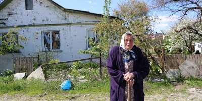 An elderly woman near her damaged home in Chernihiv Region. Photo: IOM 2022