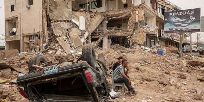 Residents sit amid the rubble of a neighbourhood in the southern Lebanese city of Tyre after an Israeli strike on 18 April 2026. Months of war have displaced more than a million people and deepened political divisions across Lebanon. -  Louisa Gouliamaki / Reuters