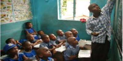 This Picture Shows a Teacher in Class with School children. This Is The Best Time To Start Teaching Children About Corruption And Its Vices