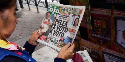 A newspaper vendor reads the front page of a newspaper that reads in Spanish: The fight is vote by vote in Lima, Peru, Monday, June 8, 2026, a day after the presidential election runoff. - Rodrigo Abd, AP