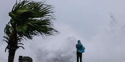 A person looks on as large waves crash against the coast as Typhoon Bavi passes off northeastern Taiwan, in Keelung on July 11, 2026. -  I-Hwa Cheng, AFP
