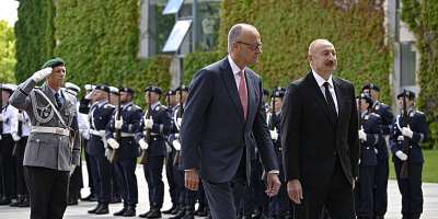 German Chancellor Friedrich Merz (L) and Azerbaijans President Ilham Aliev (R) react after inspecting the honor guard during a welcoming ceremony at the Chancellery in Berlin on July 21, 2026. - AFP - TOBIAS SCHWARZ