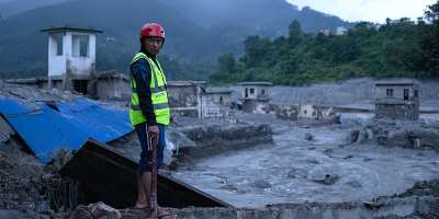 A rescue worker looks on at the site of damaged buildings in the aftermath of flash floods at Trishuli Bazar in Nepals Nuwakot district on August 29, 2026. -  Manan Vatsyayana, AFP