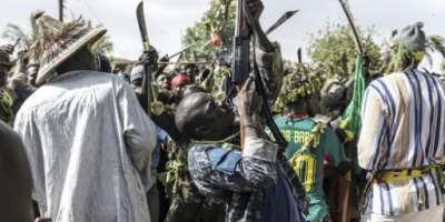 A man shoots down a bird as he arrives with other hunters to display their catch to community members at an arena, during the Miss de Diobaye on July 13, 2026.  By PATRICK MEINHARDT (AFP)