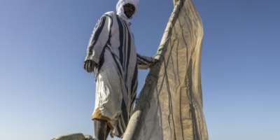 Samata Mahmoud unfurls the sail on his lanche boat in Mauritanias Banc dArguin National Park. By PATRICK MEINHARDT (AFP)