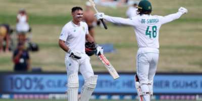 South Africa's David Bedingham left is congratulated after reaching his hundred by Ruan de Swardt.  By Fiona Goodall AFP
