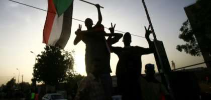 Sudanese protesters wave the national flag outside the military headquarters in the capital Khartoum on May 19, 2019 as talks were to resume between the military rulers and leaders of the demonstrators on a new governing body. By ASHRAF SHAZLY (AFP)