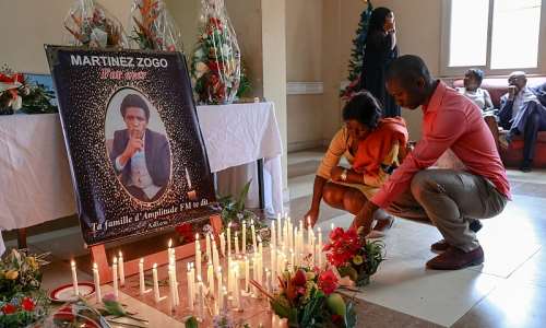 Mourners place candles in front of a portrait of murdered Cameroonian journalist Martinez Zogo, at his outlet Radio Amplitude FM, in Yaound, on January 23, 2023. AFPDaniel Beloumou Olomo