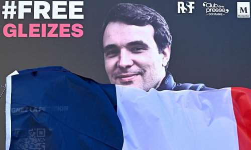 A portrait of French journalist Christophe Gleizes, who is detained in Algeria, is unveiled during a demonstration organised by the Occitanie Press Club and rights group Reporters Without Borders (RSF) to demand his release in Montpellier, southern France on January 29, 2026. -  Gabriel Bouys, AFP