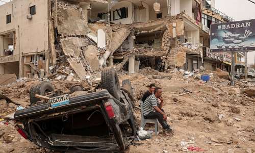 Residents sit amid the rubble of a neighbourhood in the southern Lebanese city of Tyre after an Israeli strike on 18 April 2026. Months of war have displaced more than a million people and deepened political divisions across Lebanon. -  Louisa Gouliamaki / Reuters
