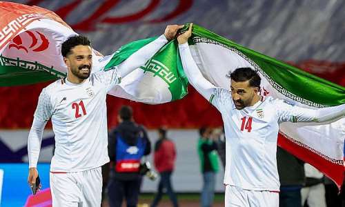 AFP via Getty Images: Iran players Omid Norafkan and Saman Ghoddos celebrate after a qualifying match in 2025
