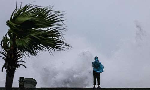 A person looks on as large waves crash against the coast as Typhoon Bavi passes off northeastern Taiwan, in Keelung on July 11, 2026. -  I-Hwa Cheng, AFP