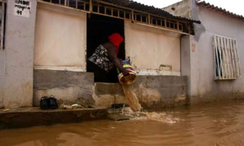 A woman was spotted scooping brown water out of the windows of her house with a large plastic bucket. By Osvaldo Silva (AFP)