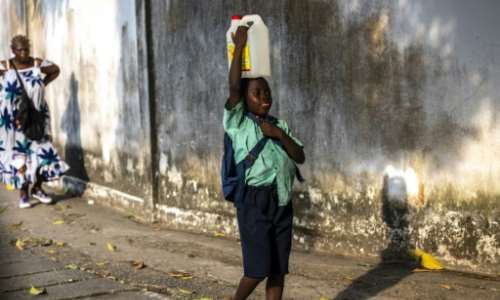 Many people in Douala have to walk long distances to haul water back home. By Charly TRIBALLEAU AFP