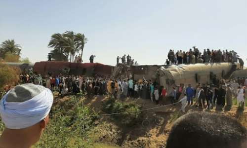 People gather on and around the wreckage of two trains that collided in the Tahta district of Sohag province, some 460 kms south of the Egyptian capital Cairo on March 26. By - (AFP/File)