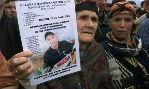 The grandmother of Massinissa Guermah, a teenager killed by Algerian police in April 2001, holds aloft his picture in May that year, amid protests in the country's Berber heartland. By - (AFP/File)