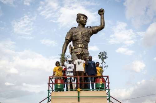 Revolutionary figure: People pose next to a statue of Sankara in Ouagadougou at ceremonies to mark the 34th anniversary of his assassination.  By OLYMPIA DE MAISMONT (AFP)