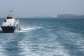 A patrol boat moves through the water as cargo ships sit at anchor in the Strait of Hormuz off Bandar Abbas, Iran, Saturday, 2 May 2026. - AP - Amirhosein Khorgooi