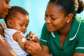 A Ghanaian nurse administering a malaria vaccine to an infant.