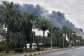 (FILE) Smoke rises from Kuwait international airport after a drone strike on fuel storage on March 25, 2026. - AP