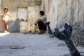 A man speaks with a child while sitting near an unexploded artillery shell that fell during reported overnight Israeli bombardment that hit the village of Abidin in Syrias southwestern Daraa province, close to the Golan Heights, on June 29, 2026. -  AFP, Sam Hariri