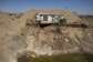 A house overlooks an open pit dug by illegal miners in Bapong, a mining village in North West province.  By EMMANUEL CROSET (AFP)