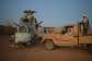 An Azawad Liberation Front fighter next to a damaged Mi-24 helicopter at the former Russian mercenary barracks in Kidal on May 6.  By - (AFP)