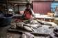 Sirah Darboe-Manneh, 31, a fishmonger and mother of six, cleans fish in Tanji, The Gambia.  By MUHAMADOU BITTAYE (AFP)