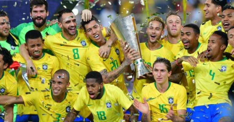 Neymar and Firmino celebrate with a trophy after beating Argentina. Photograph: Waleed Ali/Reuters