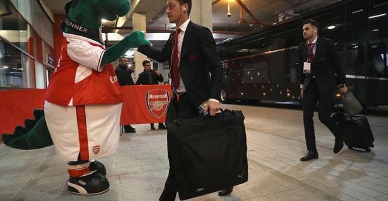 Ozil pictured shaking hands with Gunnersaurus ahead of a match at the Emirates Stadium