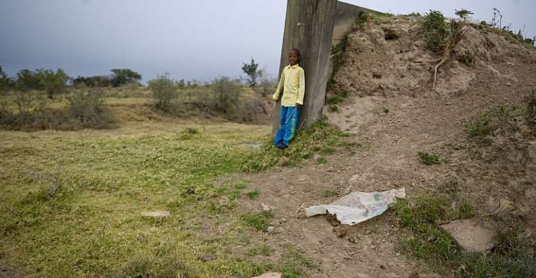 Young Sandi Sile on an abandoned structure in Makhanda, South Africa, in 2013. Questions remain about how the new law will treat abandoned land. - Source: Getty Images
