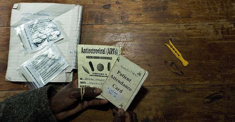 A person living with HIV shows her clinic appointment and anti-retroviral drugs regimen card. - Source: TONY KARUMBA/AFP/GettyImages