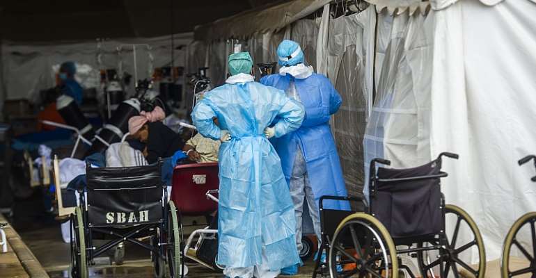 Health care workers and patients in the temporary outside area Steve Biko Academic Hospital created to screen and treat suspected Covid-19 cases in Pretoria. - Source: Alet Pretorius/Gallo Images via Getty Images