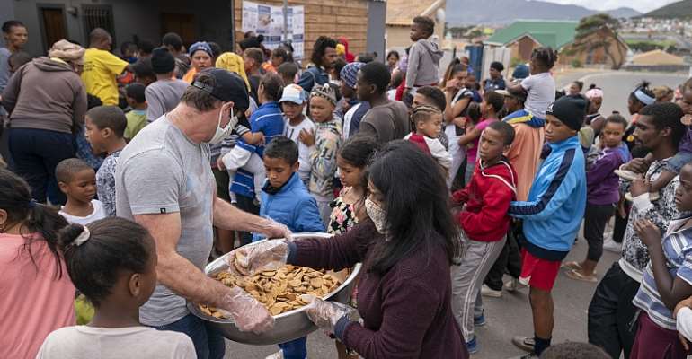 Children receive biscuits and other foods from the Groundbreakers community feeding programme in Ocean View, Cape Town.
- Source: EPA-EFE/Nic Bothma